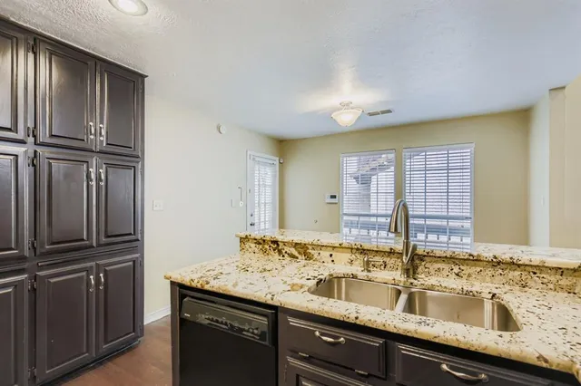 a kitchen with granite countertop a sink and stainless steel appliances