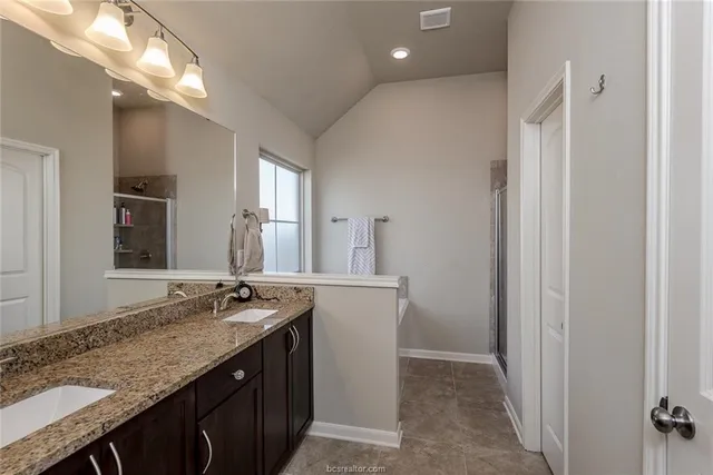 a bathroom with a granite countertop sink and a mirror