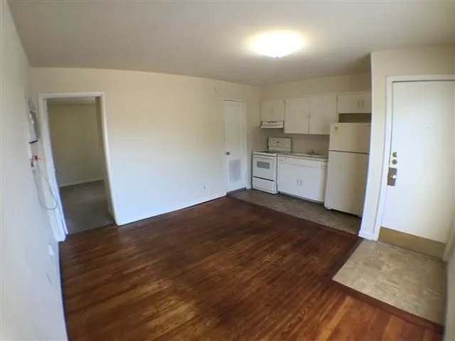 a kitchen with a refrigerator and white cabinets