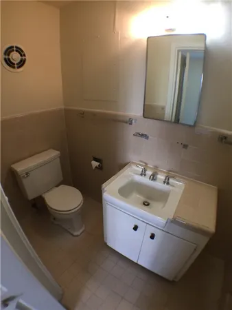 a bathroom with a toilet sink and mirror