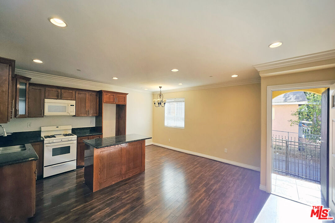 1432 1/2 Ricardo Street Los Angeles, CA 90033 - Photo 4 of 21 a kitchen with stainless steel appliances granite countertop a stove top oven a sink and a granite counter tops with wooden floors