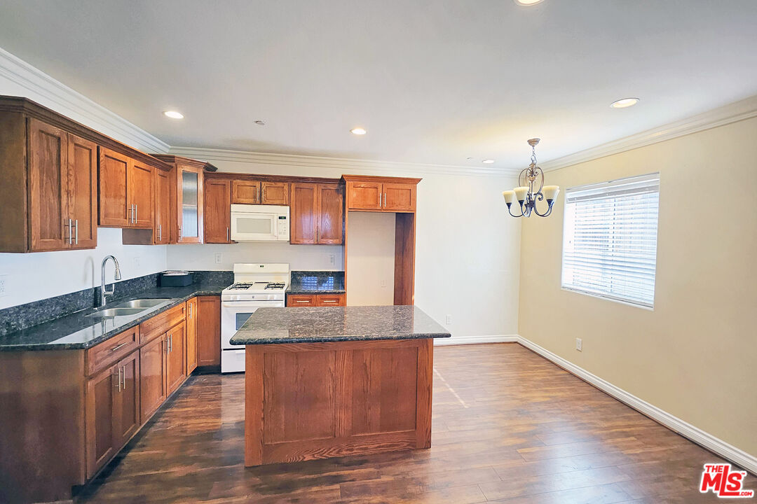 1432 1/2 Ricardo Street Los Angeles, CA 90033 - Photo 5 of 21 a large kitchen with stainless steel appliances granite countertop a sink a stove a counter space and wooden floor