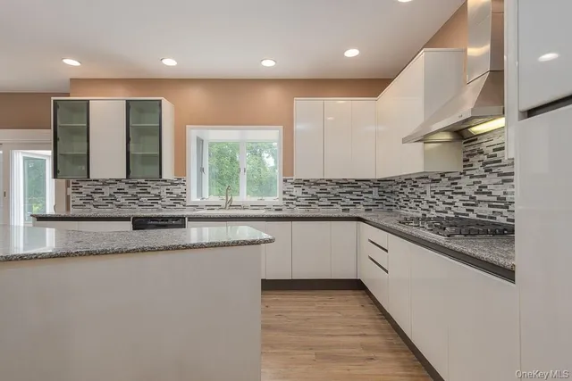 a bathroom with a granite countertop sink and a large mirror
