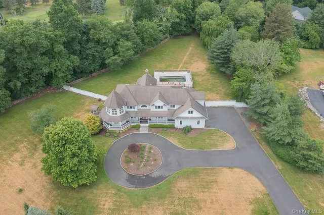 an aerial view of a house with swimming pool and lake view