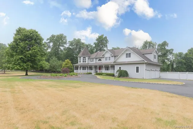 a view of a house with a big yard and large trees