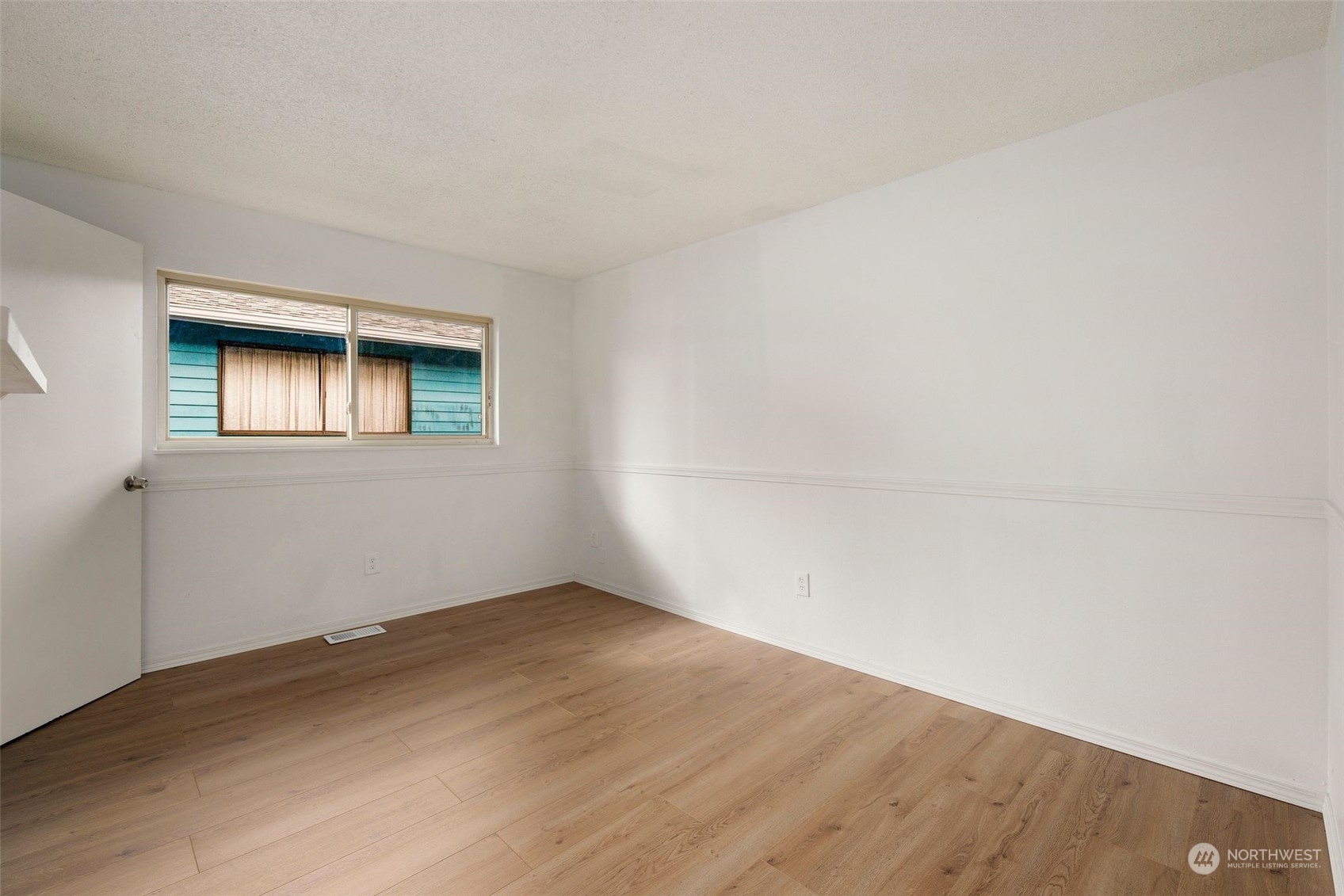 10705 Southeast 236th Place Kent, WA 98031 - Photo 7 of 36 a view of an empty room with wooden floor and a window