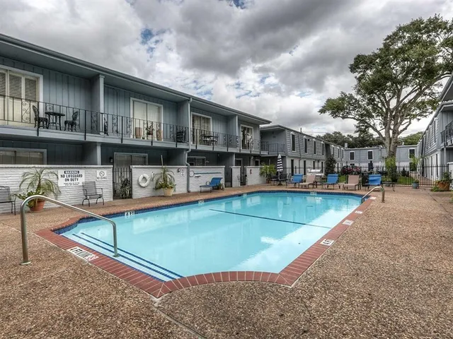 a view of a building with a swimming pool and sitting area