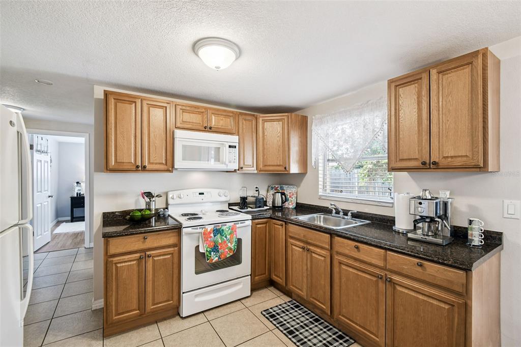 10801 Bethel Street Port Richey, FL 34668 - Photo 12 of 28 a kitchen with stainless steel appliances granite countertop white cabinets sink stove and granite counter top