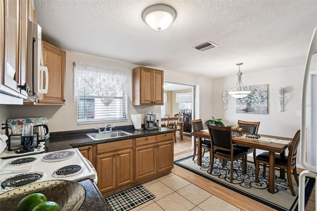 10801 Bethel Street Port Richey, FL 34668 - Photo 13 of 28 a kitchen with sink a stove and chairs