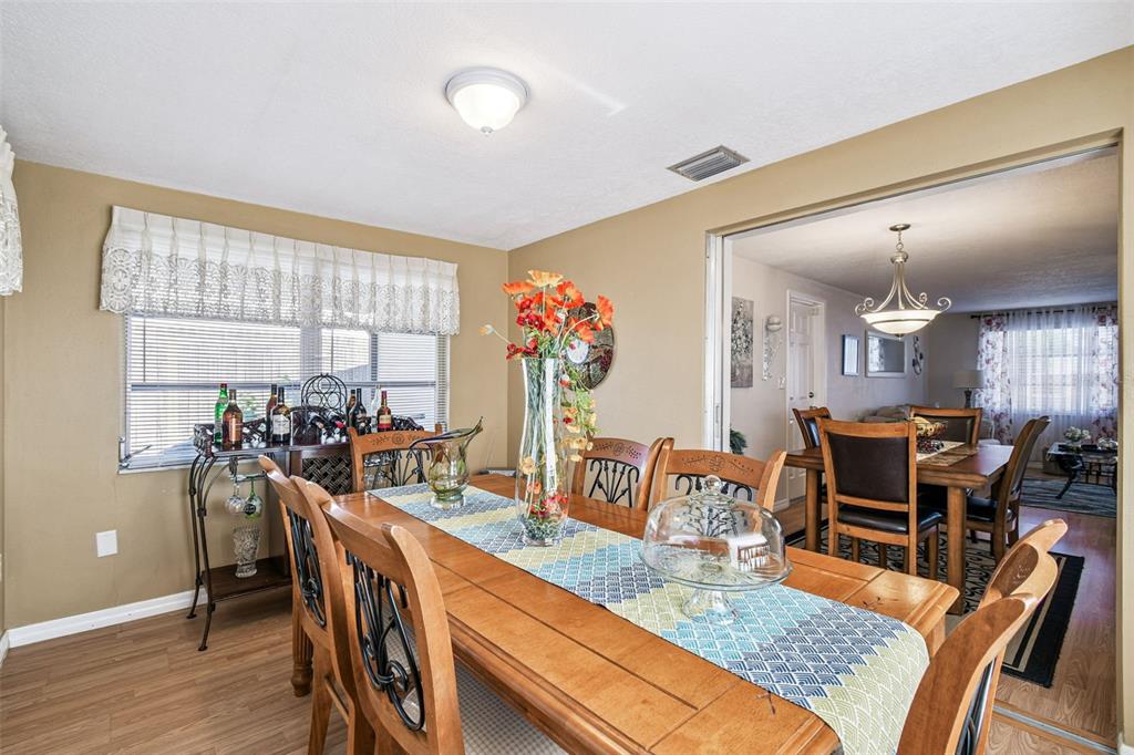 10801 Bethel Street Port Richey, FL 34668 - Photo 16 of 28 a view of a dining room with furniture window and wooden floor