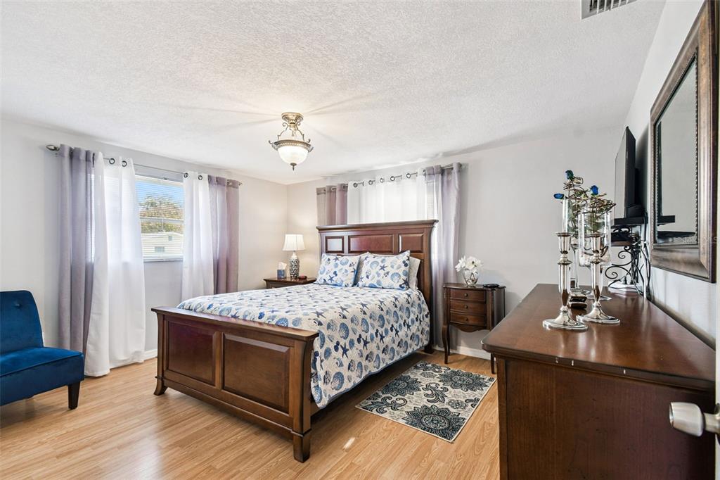 10801 Bethel Street Port Richey, FL 34668 - Photo 18 of 28 a bedroom with a bed and wooden floor