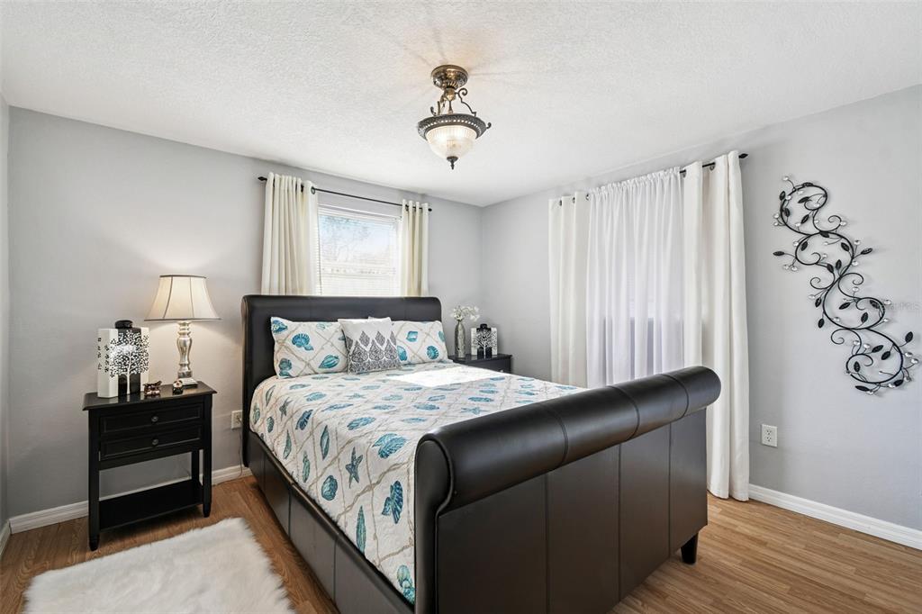 10801 Bethel Street Port Richey, FL 34668 - Photo 21 of 28 a bedroom with a bed and wooden floor