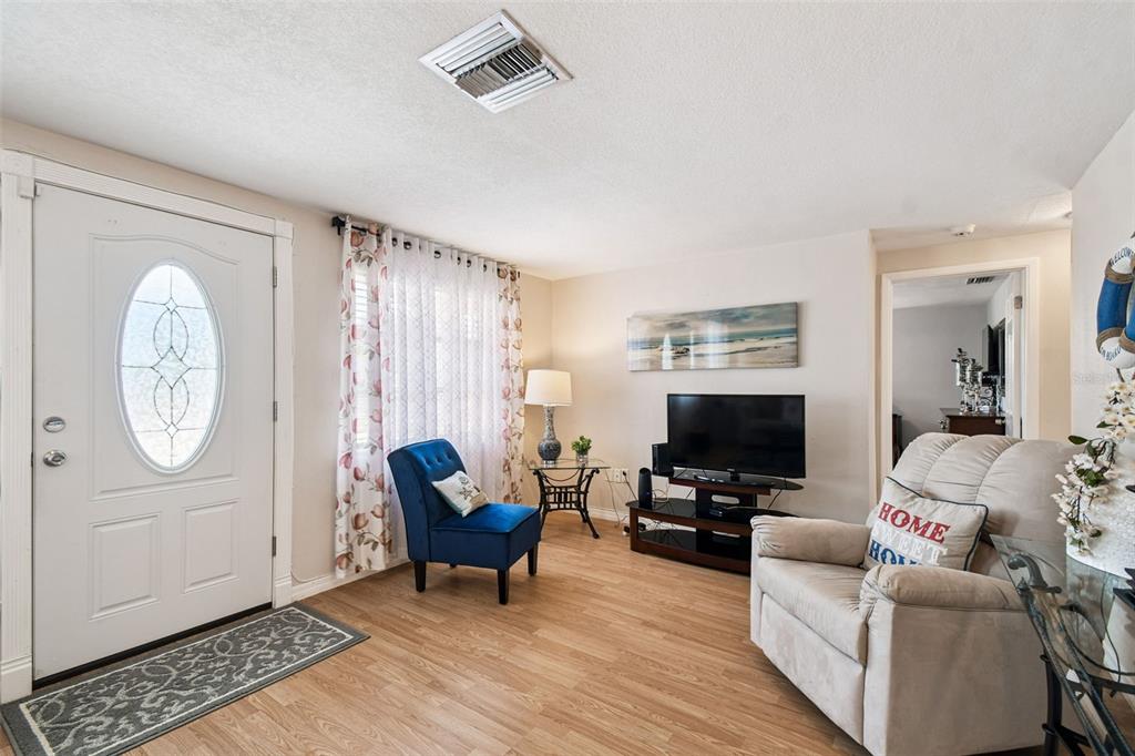 10801 Bethel Street Port Richey, FL 34668 - Photo 4 of 28 a living room with furniture a flat screen tv and a window