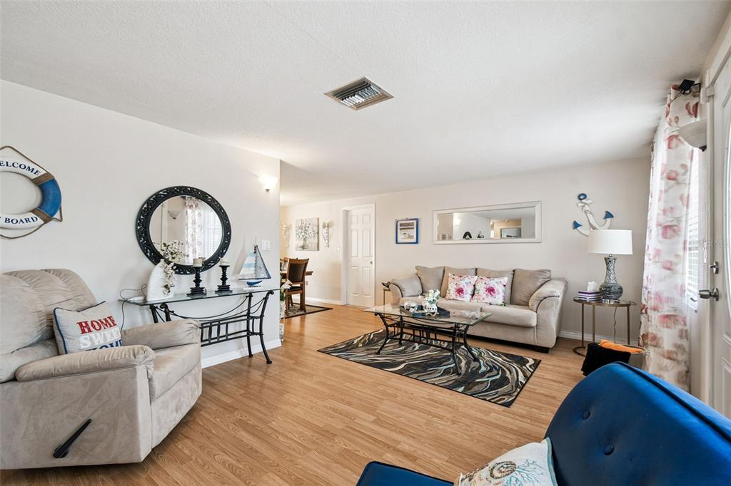 10801 Bethel Street Port Richey, FL 34668 - Photo 6 of 28 a living room with furniture and a wooden floor