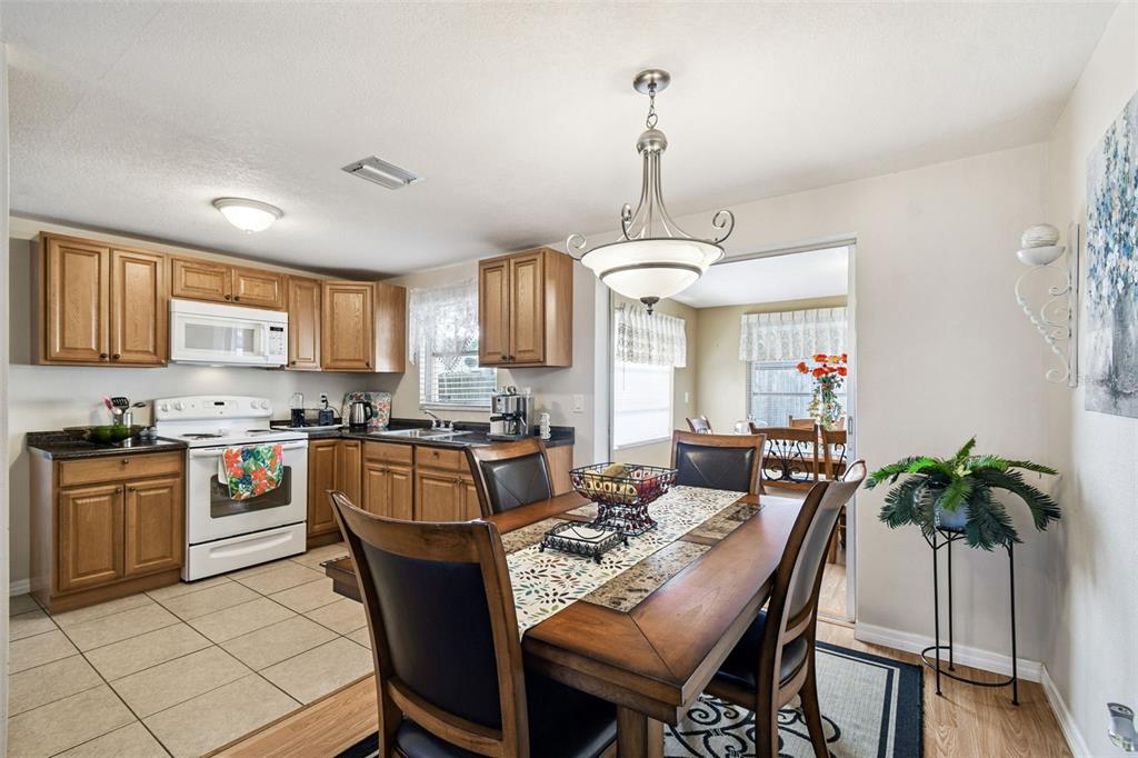 10801 Bethel Street Port Richey, FL 34668 - Photo 10 of 28 a living room with stainless steel appliances kitchen island granite countertop furniture and a kitchen view