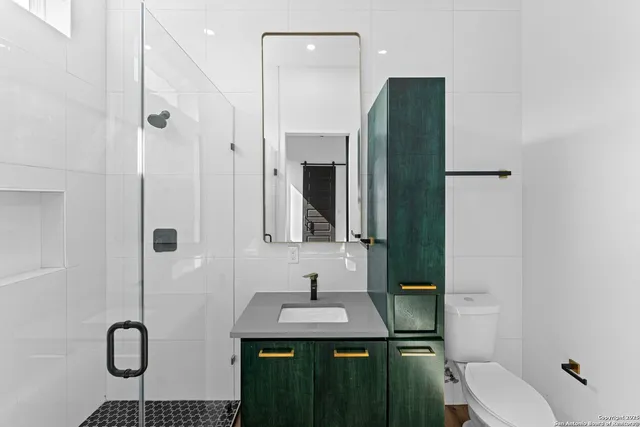a bathroom with a granite countertop sink toilet and shower