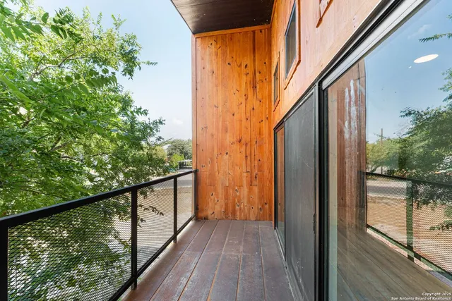 a view of balcony with wooden floor and floor to ceiling window