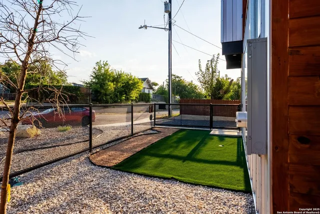 an aerial view of residential houses with outdoor space and trees all around