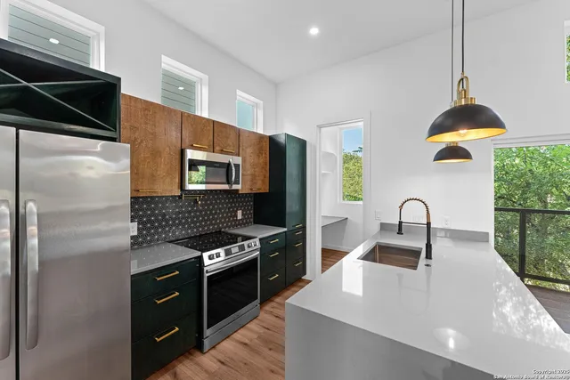 a kitchen with stainless steel appliances granite countertop a sink and a refrigerator