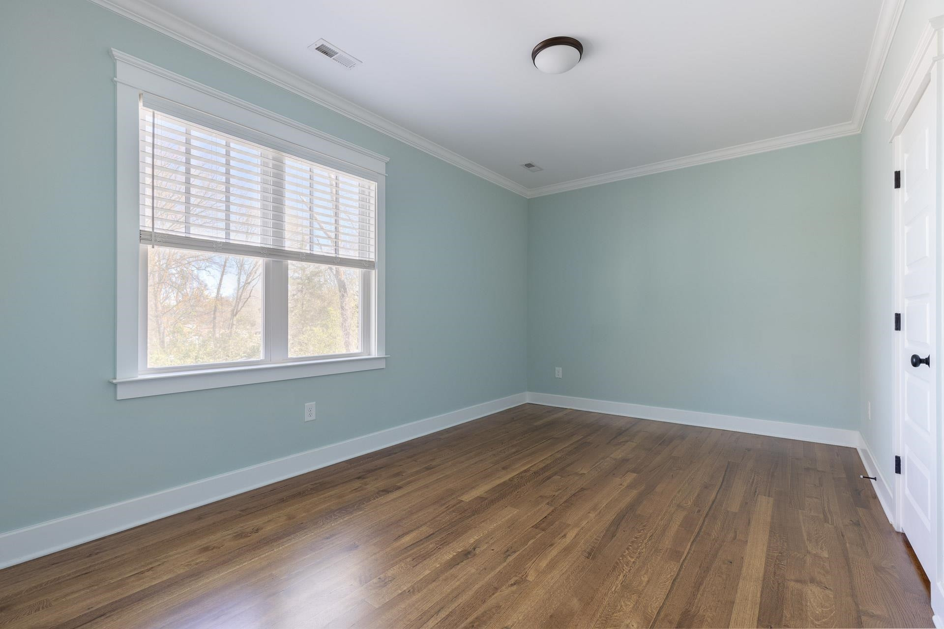 910 Sedgefield Street Durham, NC 27705 - Photo 34 of 39 an empty room with wooden floor and windows