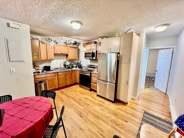 a kitchen with stainless steel appliances a refrigerator sink and wooden floor