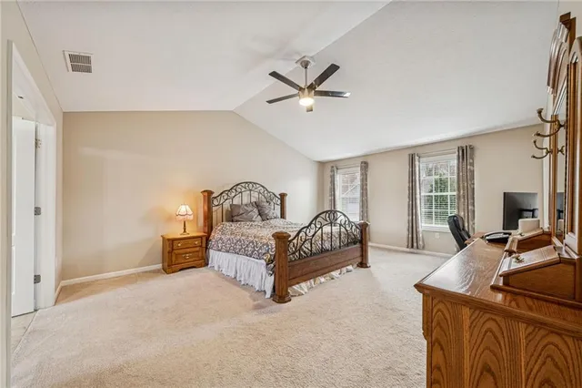 a bedroom with a large bed and wooden floor