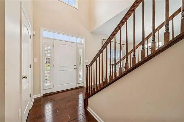 a kitchen with stainless steel appliances granite countertop wooden floors stove top oven with a dining table and chairs