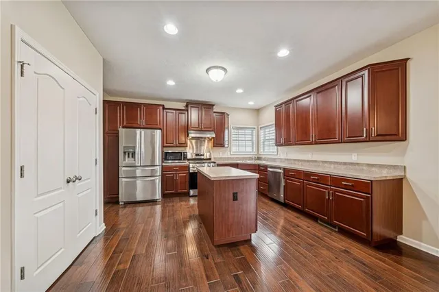 a kitchen with a table chairs refrigerator and cabinets