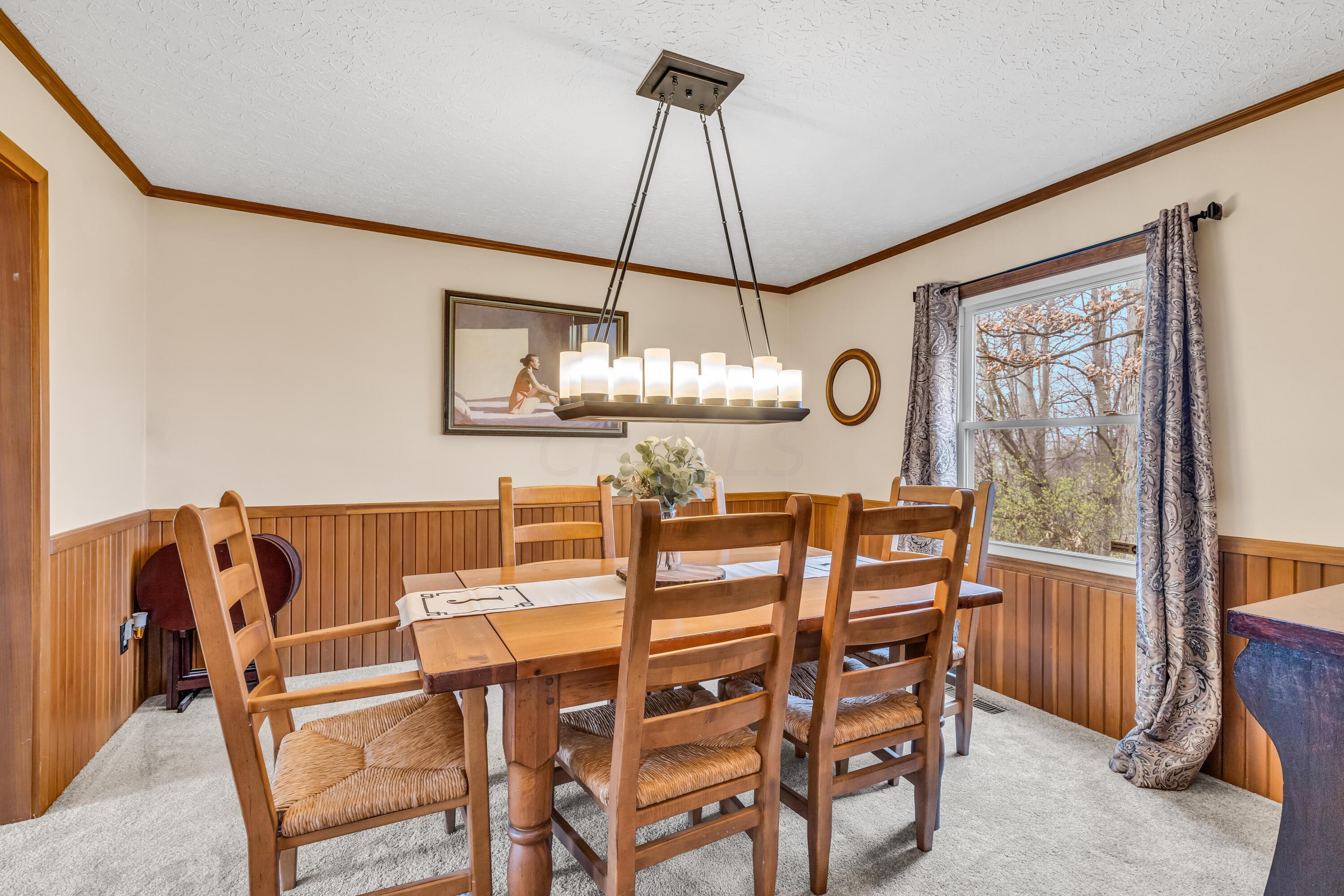 435 Emory Street Gahanna, OH 43230 - Photo 12 of 54 • New light sand
carpet ~ 2022
• Vanilla painted & half
wainscoted walls
• Crown molding
• Chair railing
• New chandelier ~ 2020
• Drapes remain