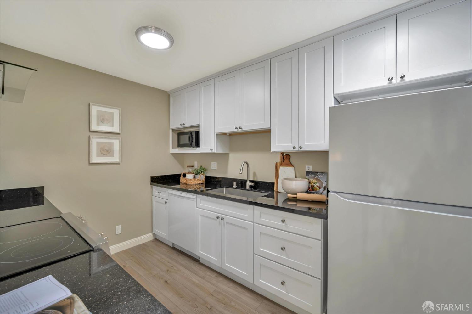 1585 10th Avenue, Unit 3 San Francisco, CA 94122 - Photo 10 of 32 a kitchen with granite countertop white cabinets and white appliances
