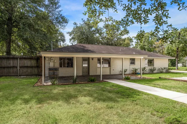 a front view of house with a garden and trees