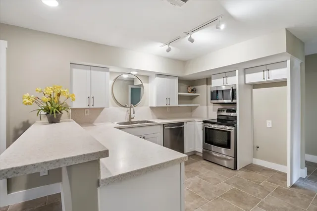 a kitchen with stainless steel appliances granite countertop a stove a sink and a refrigerator