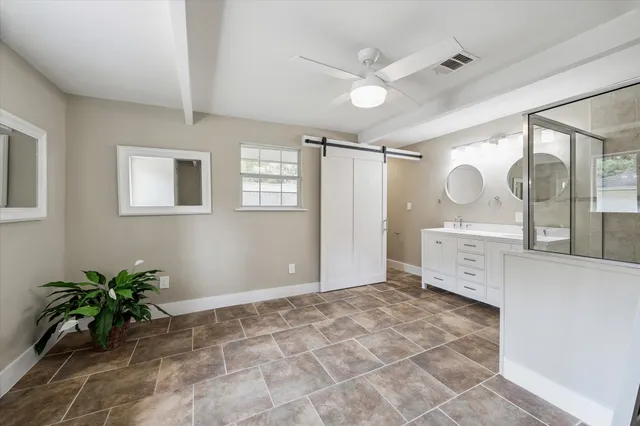 a spacious bathroom with a shower sink and mirror
