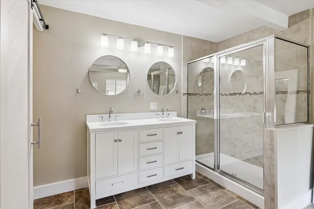 a bathroom with a double vanity sink mirror and shower