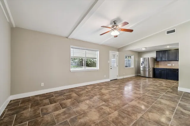a view of an empty room with window and cabinet