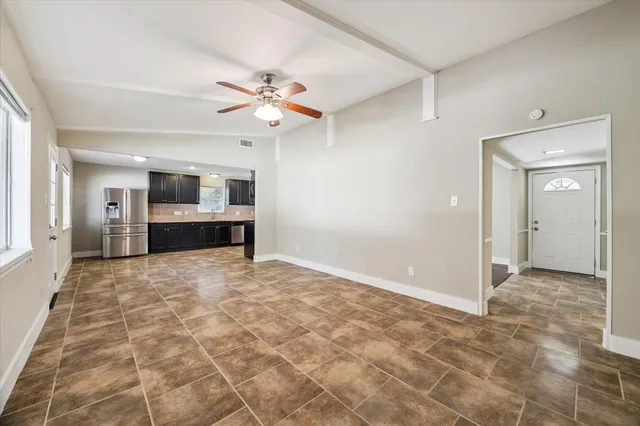 a view of empty room with a ceiling fan and window