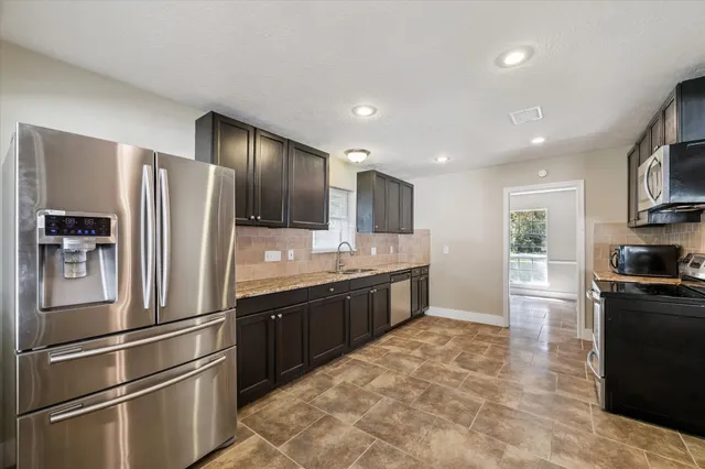a large kitchen with cabinets and stainless steel appliances