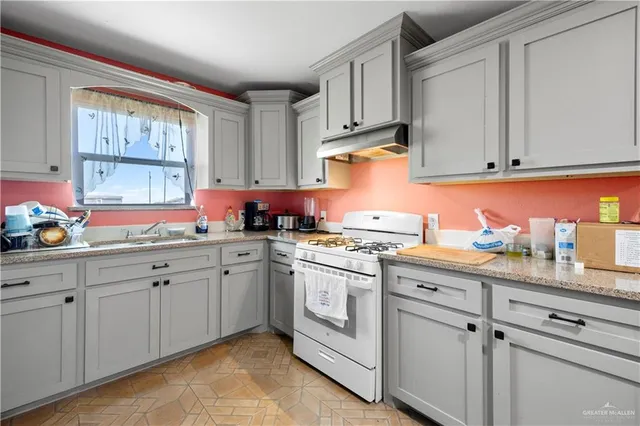 a kitchen with granite countertop white cabinets and white appliances