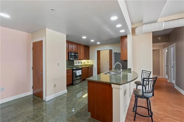 a kitchen with stainless steel appliances granite countertop a refrigerator and a sink