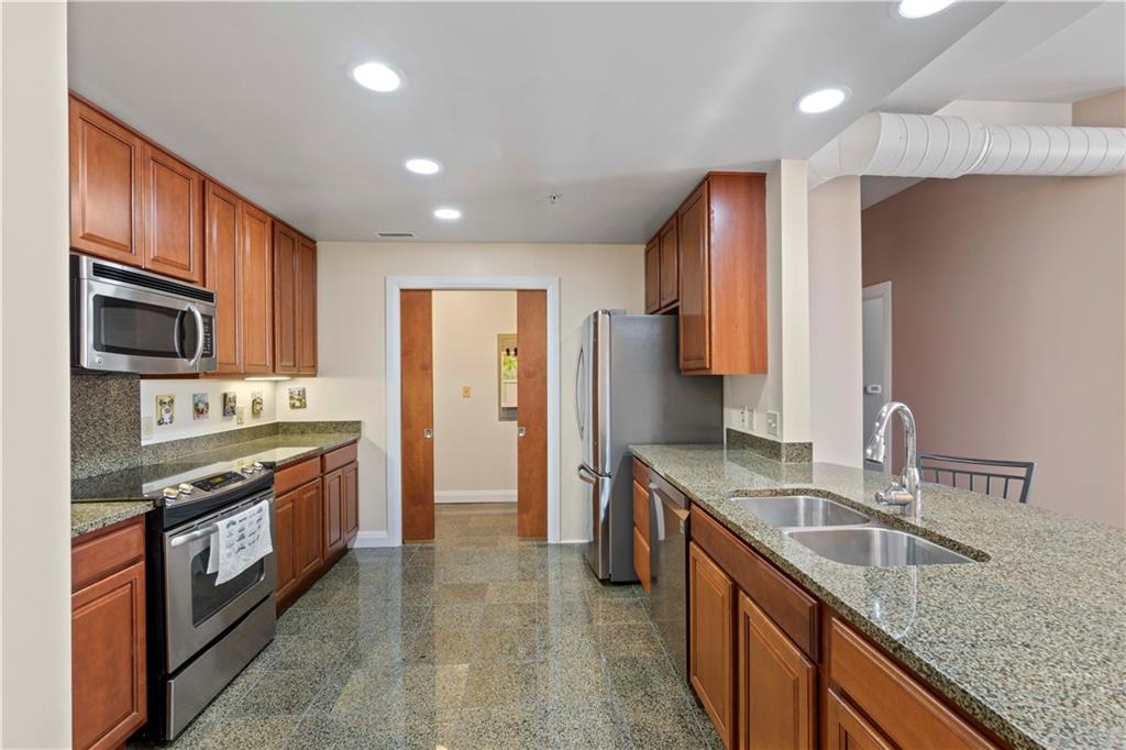 306 Fourth Avenue, Unit 1203 Pittsburgh, PA 15222 - Photo 13 of 40 a kitchen with stainless steel appliances granite countertop a sink stove and refrigerator