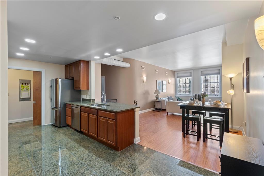 306 Fourth Avenue, Unit 1203 Pittsburgh, PA 15222 - Photo 14 of 40 a kitchen with stainless steel appliances granite countertop a table and chairs in it