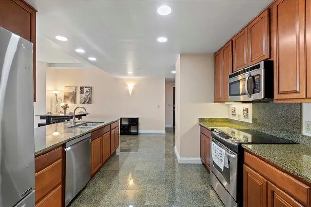 a kitchen with stainless steel appliances granite countertop a stove a sink and a microwave