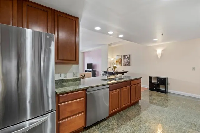 a kitchen with stainless steel appliances granite countertop a refrigerator and a stove