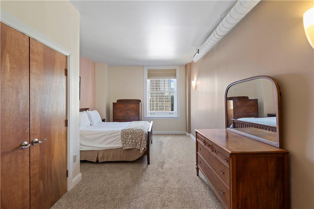 306 Fourth Avenue, Unit 1203 Pittsburgh, PA 15222 - Photo 19 of 40 a bedroom with a bed and a dresser