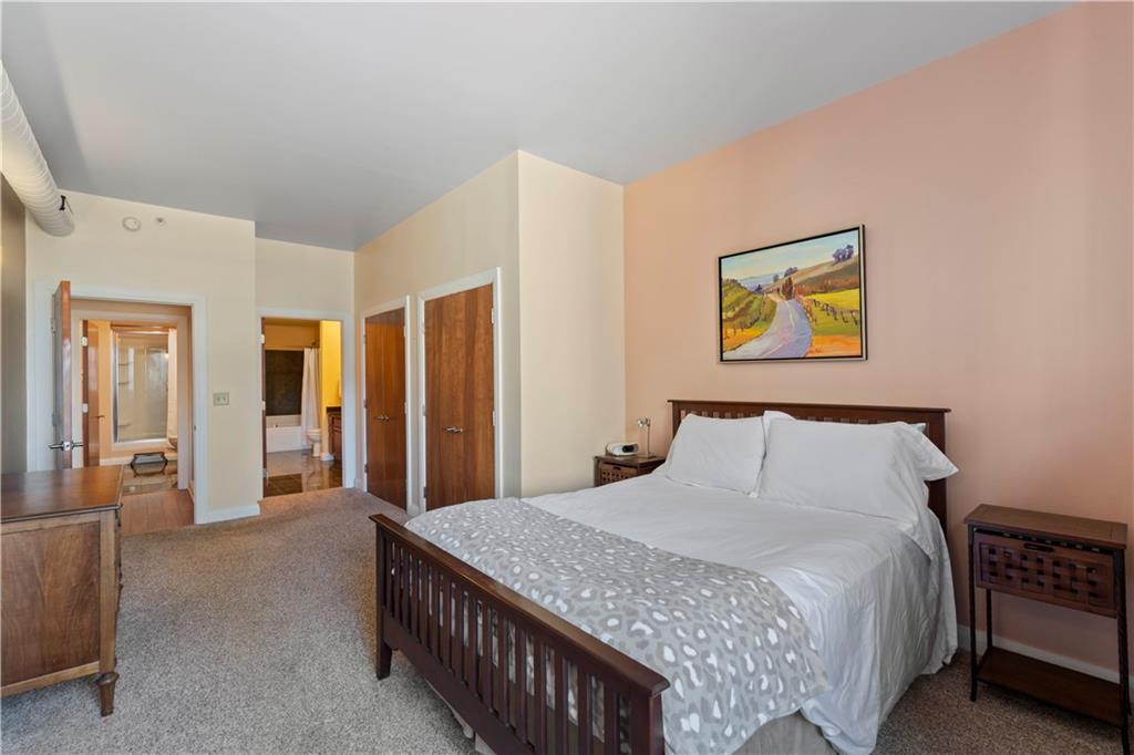306 Fourth Avenue, Unit 1203 Pittsburgh, PA 15222 - Photo 21 of 40 a bedroom with a bed and a painting on the wall