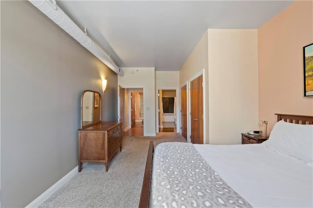 306 Fourth Avenue, Unit 1203 Pittsburgh, PA 15222 - Photo 22 of 40 a bedroom with a bed and dresser