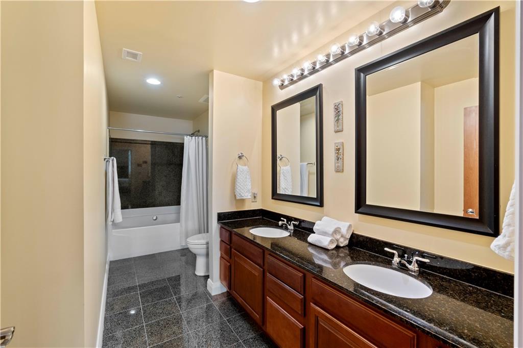 306 Fourth Avenue, Unit 1203 Pittsburgh, PA 15222 - Photo 23 of 40 a bathroom with a double vanity sink and mirror