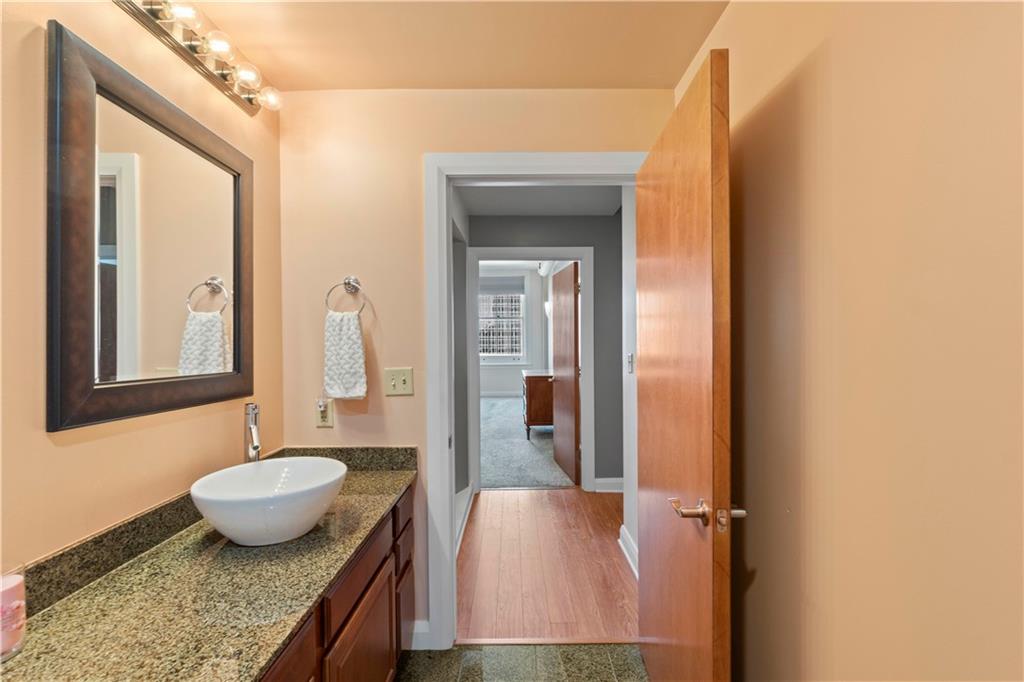 306 Fourth Avenue, Unit 1203 Pittsburgh, PA 15222 - Photo 28 of 40 a bathroom with a granite countertop sink and a mirror