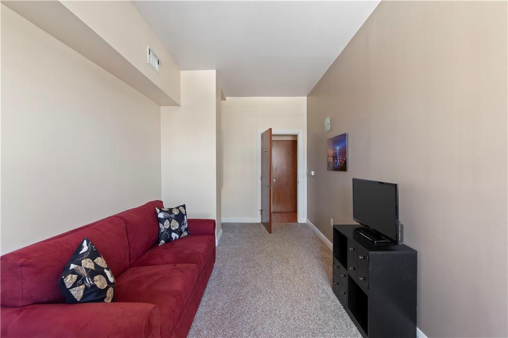 306 Fourth Avenue, Unit 1203 Pittsburgh, PA 15222 - Photo 31 of 40 a living room with furniture and a flat screen tv