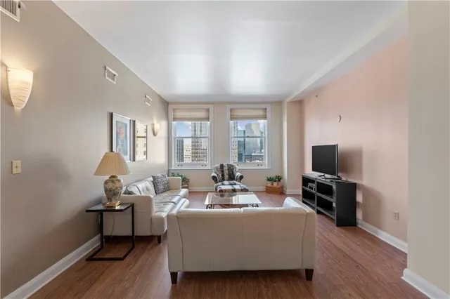 a living room with furniture wooden floor and a flat screen tv